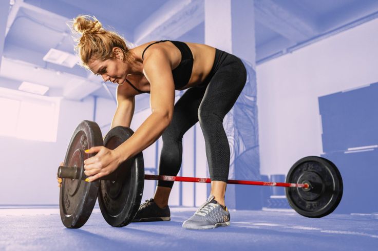바벨에 원판을 추가하며 운동 강도를 높이는 여성, 점진적 과부하 원리로 다이어트 정체기를 정면 돌파하는 모습